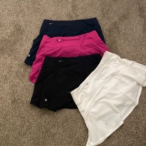 4 Lululemon size 4 skirts. Three pace rival skirts hot pink, navy,blk & wht
